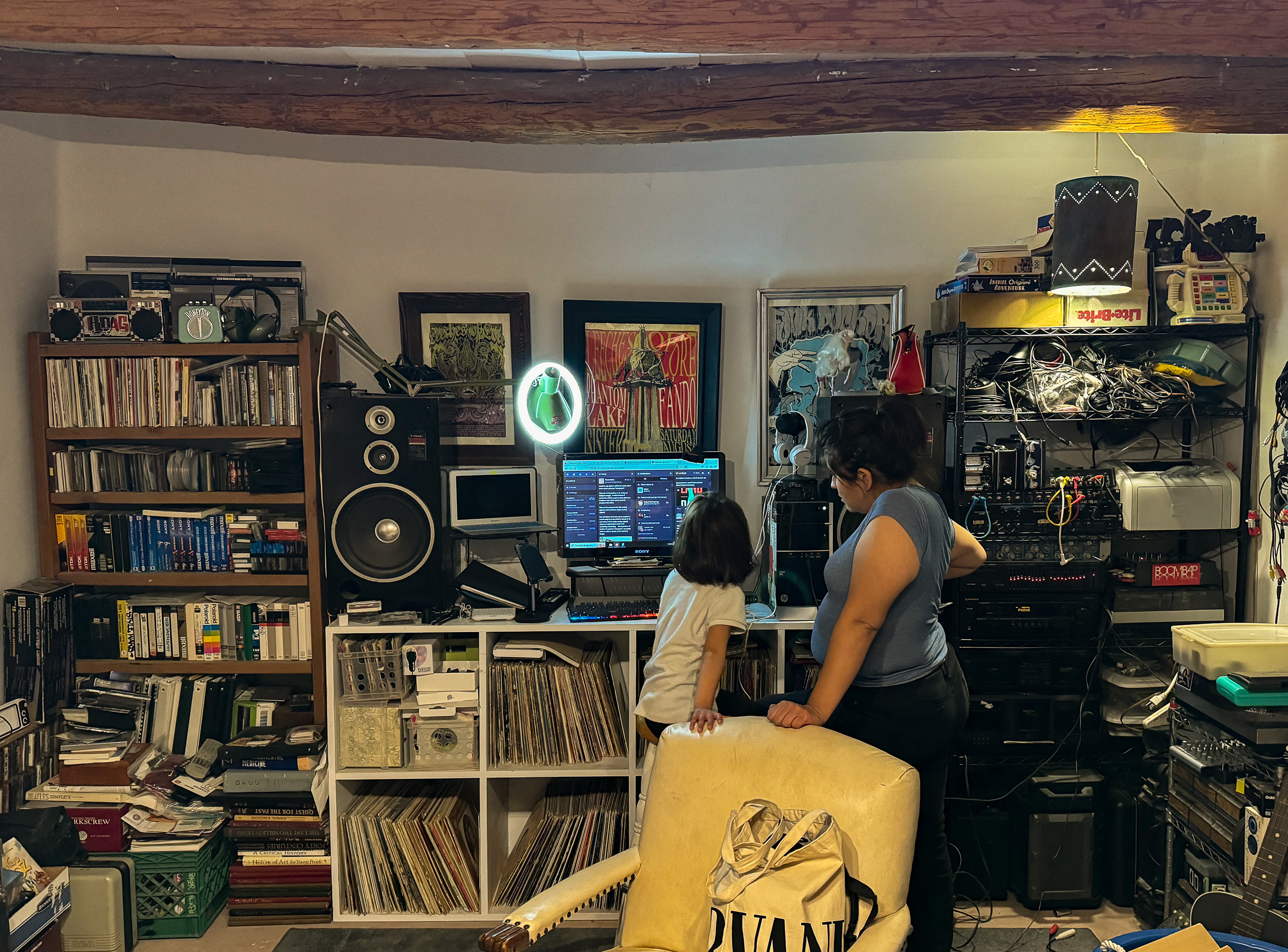 Woman and child look at computer in front of recording equipment.