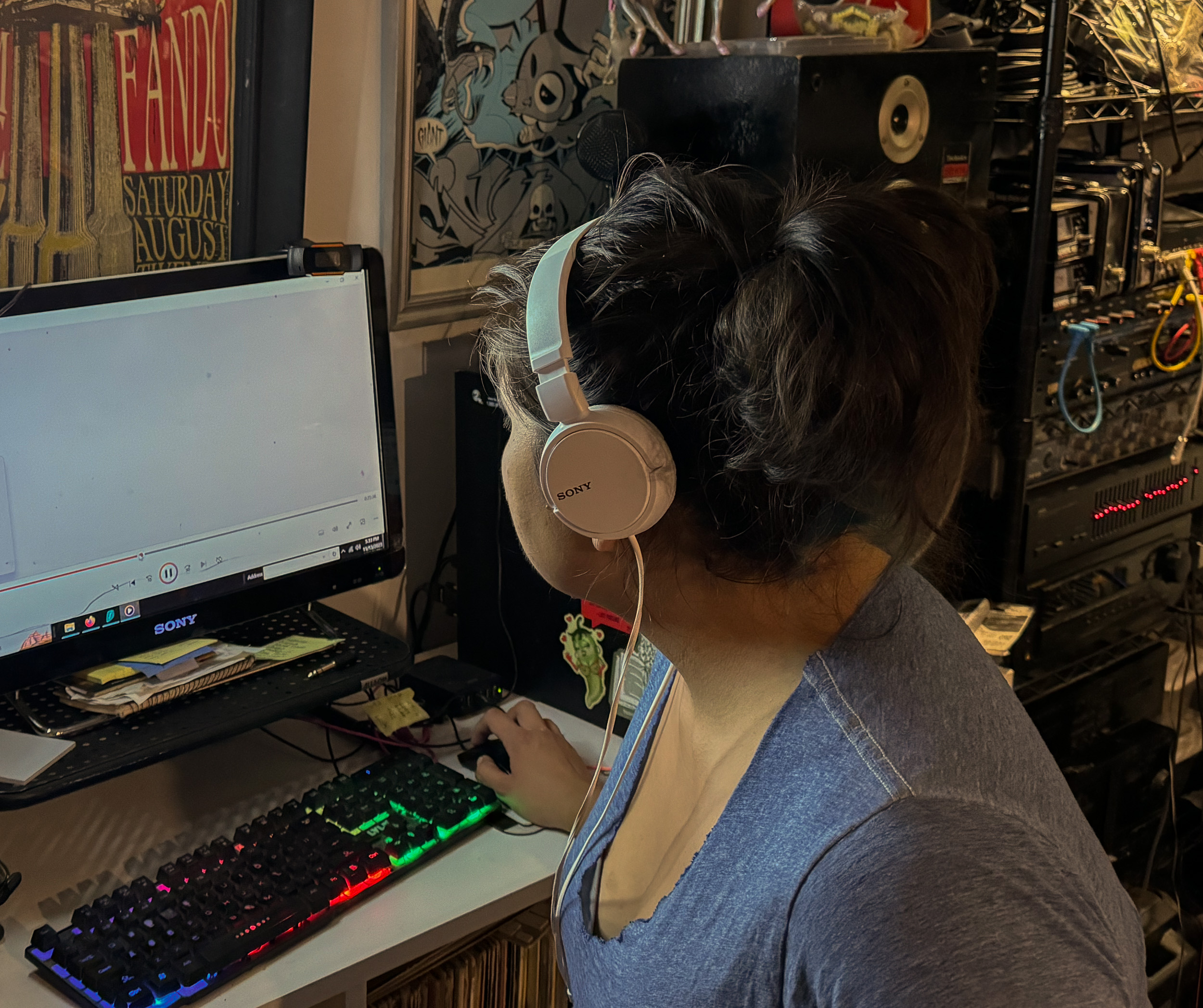 A woman wearing white headphones works on a computer