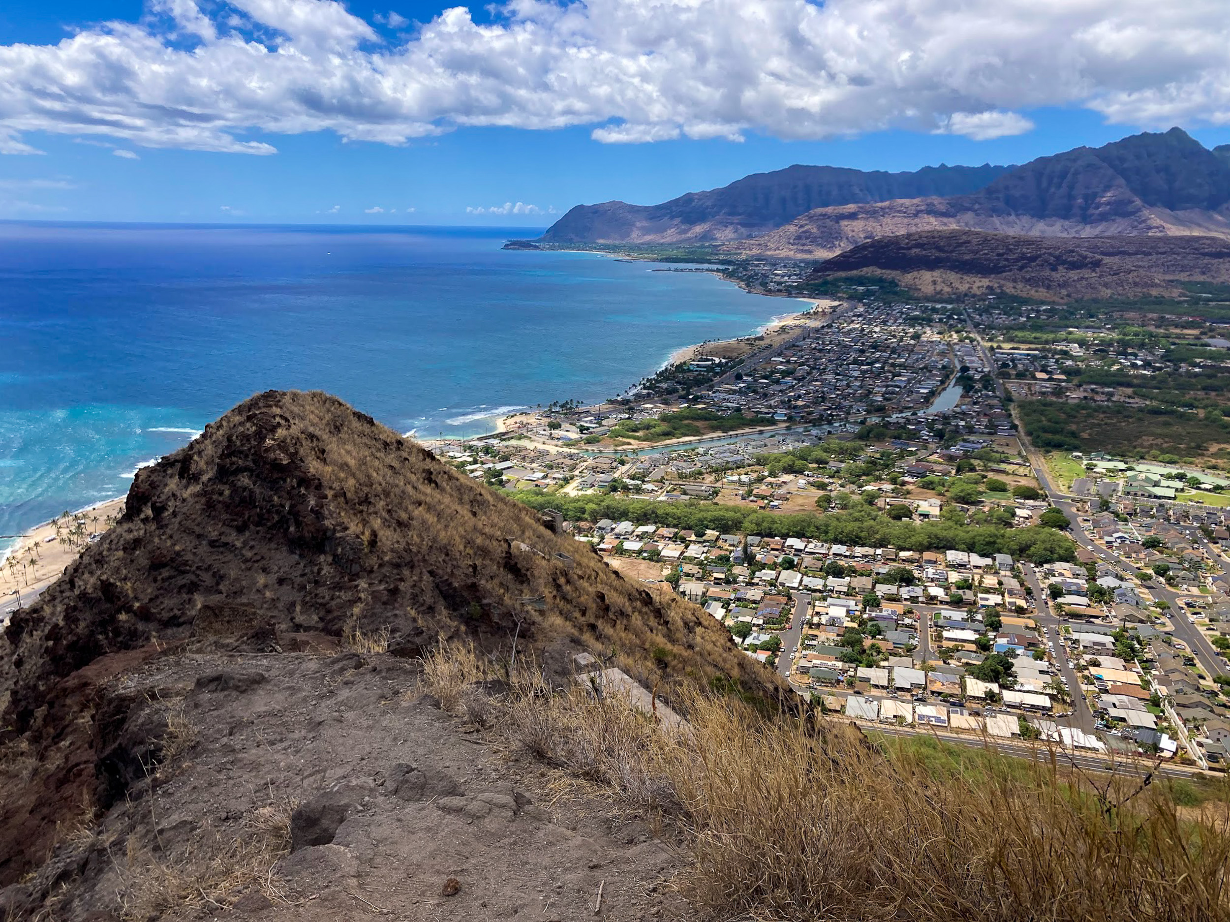 A bird’s eye view of the west side of the island of Oʻahu with beaches, neighborhoods and mountains.